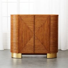 a wooden cabinet with gold accents in front of a window