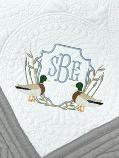 This embroidered baby quilt is stitched with a unique mallard duck scene and personalized with baby's monogram.  They make a wonderful shower gift and will be a treasured keepsake for years to come. The perfect size for cribs or strollers, quilts measure 36" x 46" and are super soft 100% cotton.  Design will be stitched as shown with your choice of color for the crest and monogram Please enter the following information in the Personalization Instructions section above: 1) Initials to be used for Mallard Nursery Theme, Mallard Duck Nursery, Mallard Duck Embroidery, Mallard Embroidery, Monogram Baby Blanket Boy, Monogrammed Muslin Baby Blankets, Duck Nursery, Hunting Baby, Personalized Baby Quilt