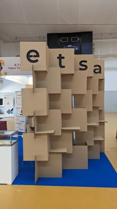 cardboard boxes are stacked on top of each other in the middle of a room with blue flooring