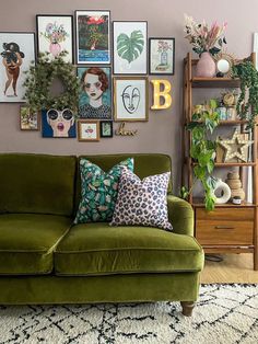 a living room with green couches and pictures on the wall