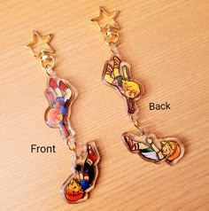 three cartoon character shaped key chains on top of a wooden table, with the words front and back written below them