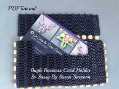 the business card holder is made out of black seed beads and gold trimmings