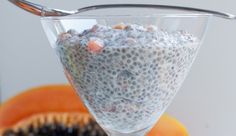 a bowl filled with oatmeal sitting on top of a table next to an orange