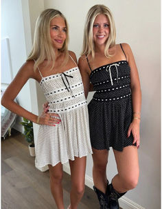 This black mini dress has white polka-dots and delicate lace trim for a cute and playful look. Adjustable self-tie white lace adds a touch of charm, while black lace detailing on the bust and midsection adds an elegant touch. With spaghetti straps and a flowy fit, this dress is both comfortable and stylish. It also features a zipper in the back for easy dressing. Easy Dressing, Black Mini Dress, New Arrival Dress, Dress Romper, Black Mini, White Polka Dot, Simple Dresses, Mini Black Dress, Lace Detail