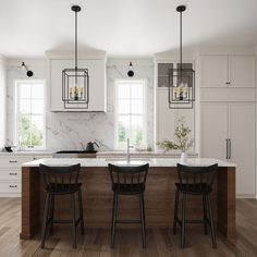 a kitchen with two stools and an island in front of the countertop is surrounded by white cabinets