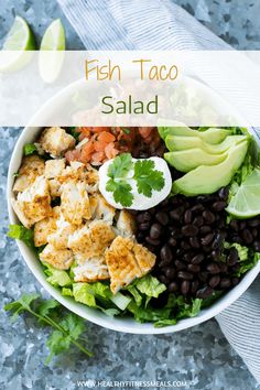 fish taco salad with black beans, avocado and cilantro in a white bowl