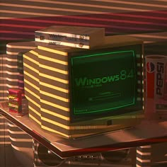 an old computer sitting on top of a table next to soda cans and other items