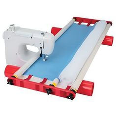 a sewing machine sitting on top of a red and white stand with a blue mat