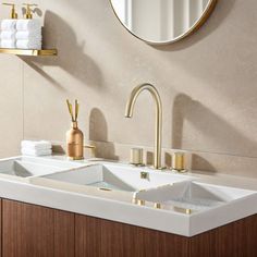 a bathroom sink sitting under a mirror next to a wall mounted faucet and towel dispenser