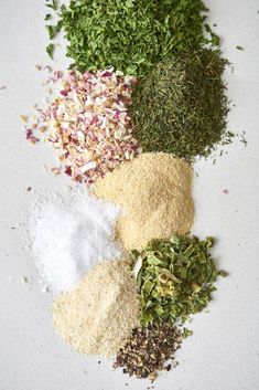 various spices and herbs on a white surface