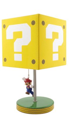 a lamp that has a mario mouse hanging from it's base with a question mark on it