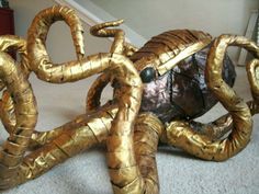 an octopus made out of gold foil on the ground