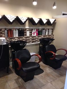 two black chairs sitting next to each other in front of a wall mounted hair dryer