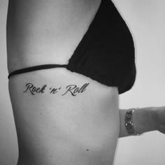 a woman's stomach with the word rock n roll tattooed on her right side