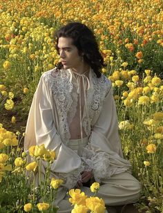 a woman sitting in a field full of yellow flowers