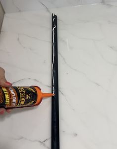 someone is using glue to paint the marble counter top with black adhesivement on it