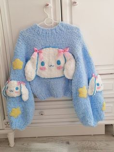 a blue sweater with white rabbit ears on it