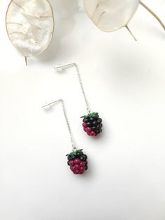 the earrings are made out of beads and silver wire, with berries hanging from them