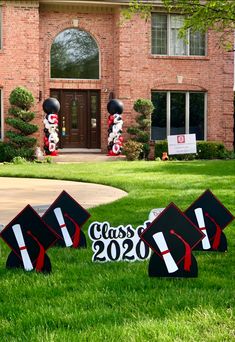 graduation yard decorations in front of a brick house with lawn signs and balloons that say class of 2020