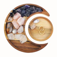 a wooden plate topped with rocks and other items next to a ring on top of it