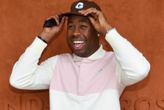 a tennis player adjusts his hat on top of his head