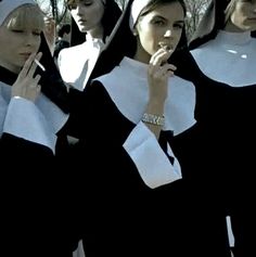 several women dressed in nun costumes are standing together with their hands on their chins