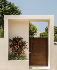 an entrance to a house with flowers growing out of it