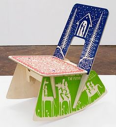 a small wooden chair with a blue and green design on it's back end