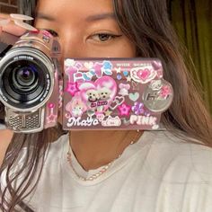 a woman holding up a camera to her face