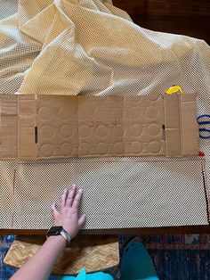 a person is laying on the floor next to some cardboard boxes and other items that have been placed around them