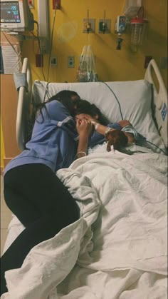 two people laying in a hospital bed next to each other