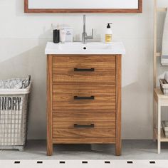 a bathroom vanity with a mirror above it and a basket under the sink next to it