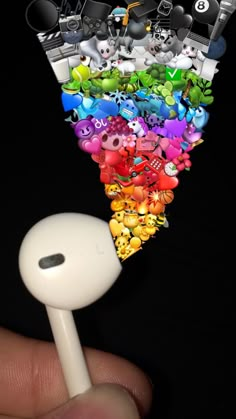 a hand holding a white headphone in front of an array of cartoon headsets