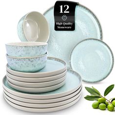 a stack of blue and white dishes next to some green olives on a white background