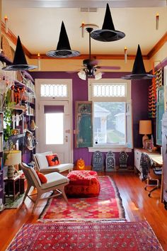 a living room filled with lots of furniture and decor on top of a hard wood floor