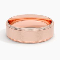 a rose gold wedding band on a white background