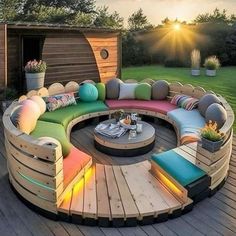 a circular couch sitting on top of a wooden deck next to a green grass covered field