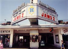 people walking in front of a movie theater with the name jawss 2 on it