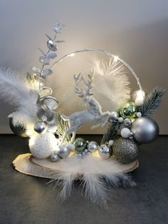 a christmas decoration with white feathers and silver ornaments