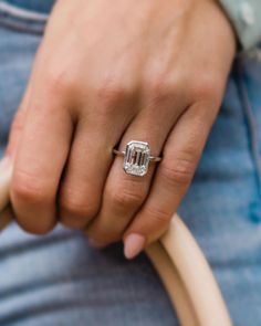 a close up of a person's hand holding a ring