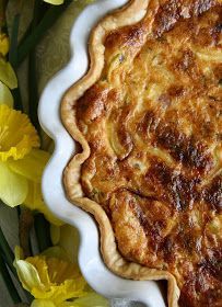 a pie sitting on top of a white plate next to yellow flowers