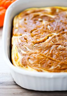 a casserole dish with oranges in the background