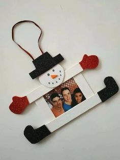 a snowman ornament hanging on a white wall