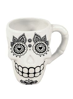 a white coffee mug with a skull face on it's side and eyes painted black