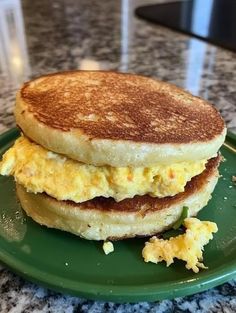 an egg and cheese sandwich on a green plate