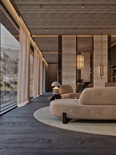 a living room filled with furniture next to a large glass window overlooking the ocean and mountains