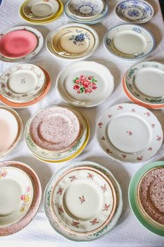 a table topped with lots of different colored plates