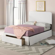 a white bed sitting on top of a hard wood floor next to a pink wall