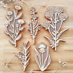 several wooden cutouts of flowers and plants on a table