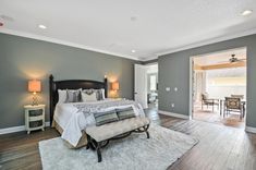 a bedroom with gray walls and hardwood floors